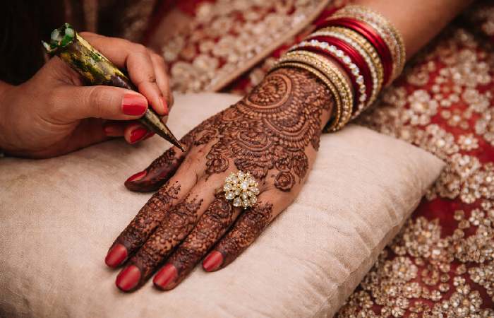 Henna artist applying bridal mehndi design