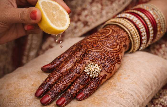 Applying lemon sugar sealant for darker mehndi